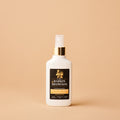 White bottle with gold cap on a beige background