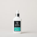 White bottle with a black label on a light gray background