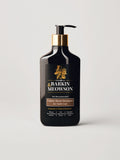 A bottle of Barkin Meowson Caramel Boost Shampoo for Dark Coat cats, featuring a matte black bottle with a gold pump collar and a black label with gold and white text, set against a light gray background.