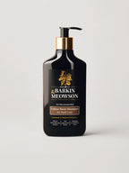 A bottle of Barkin Meowson Caramel Boost Shampoo for Dark Coat cats, featuring a matte black bottle with a gold pump collar and a black label with gold and white text, set against a light gray background.