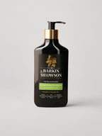 A bottle of Barkin & Meowson Deshedding Shampoo for Double Coat, in a matte black bottle with a gold pump collar and a black label featuring gold and green text, set against a light gray background.