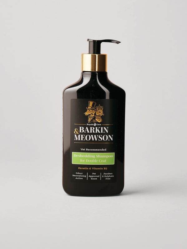A bottle of Barkin & Meowson Deshedding Shampoo for Double Coat, in a matte black bottle with a gold pump collar and a black label featuring gold and green text, set against a light gray background.