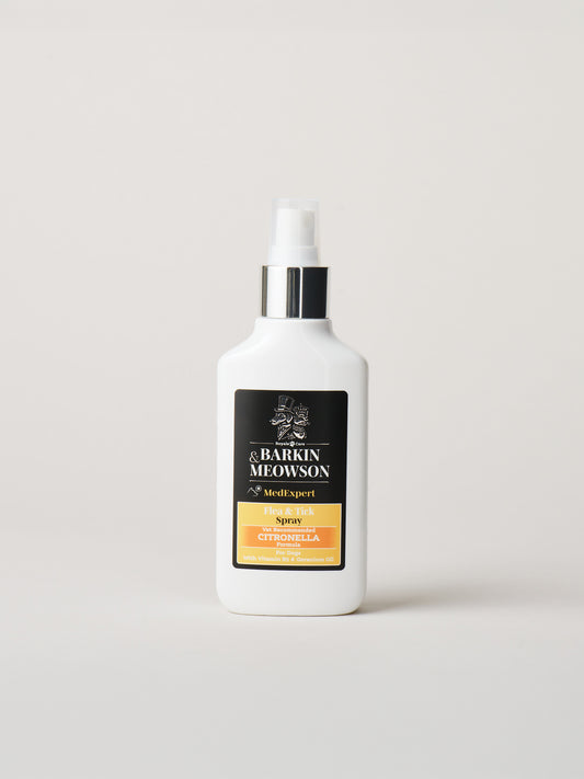 A white bottle of &Barkin Meowson Flea&Tick with a black and gold label, standing on a light gray background.
