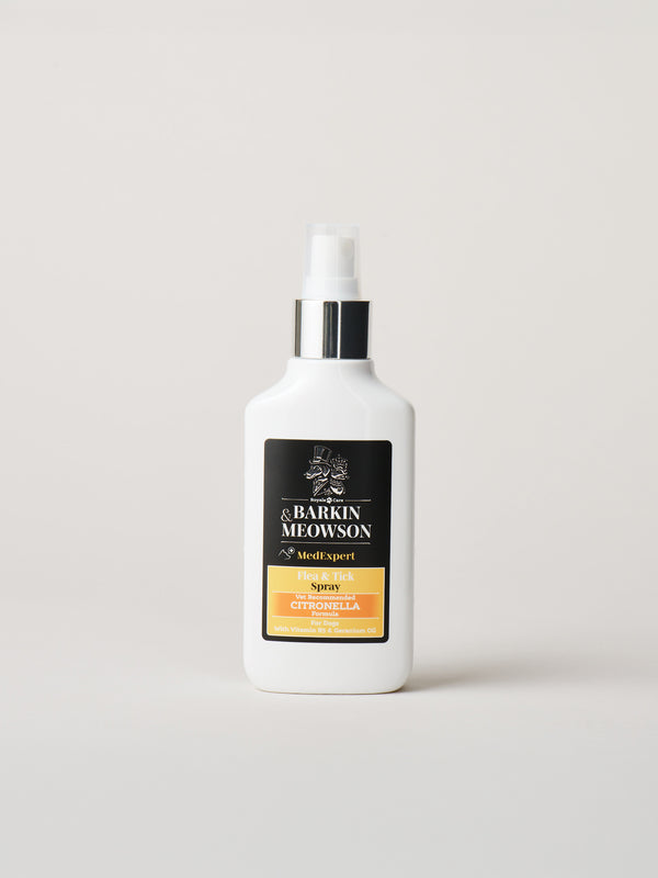 A white bottle of &Barkin Meowson Flea&Tick with a black and gold label, standing on a light gray background.