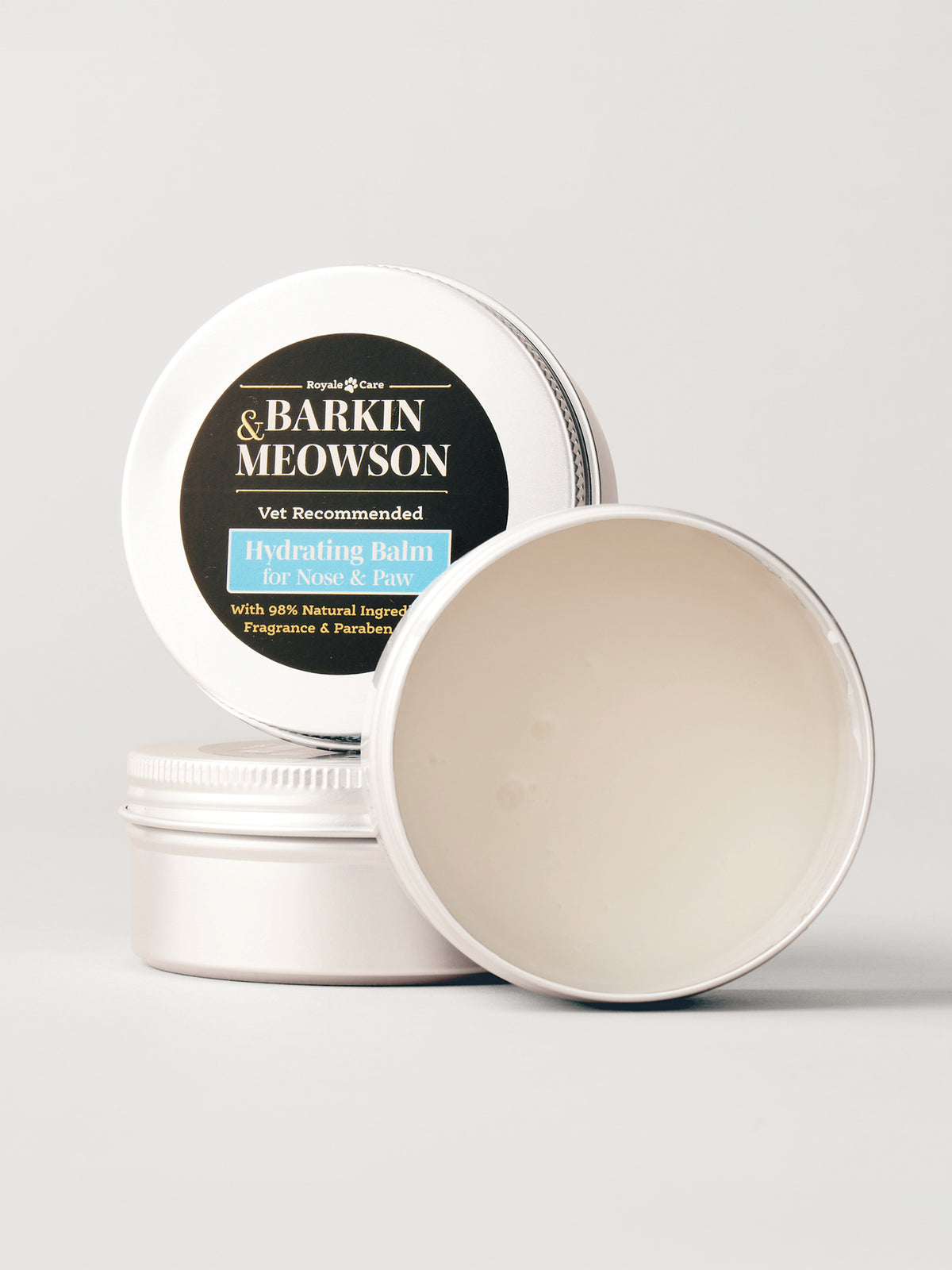 A round metal tin of Barkin&Meowson Hydrating Balm for Dogs & Cats, with one tin open to show the cream-colored balm inside and another tin standing behind showing the label.