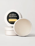 An open round metal tin of Barkin & Meowson Protecting Balm for Cats and Dogs, with the lid leaning behind it on a clean light gray background.